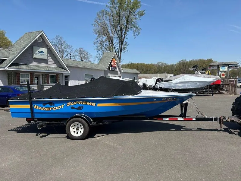 Slide: The Image of 1980 Ski Supreme boat on trailer, blue with yellow stripe, parked outdoors. - 4