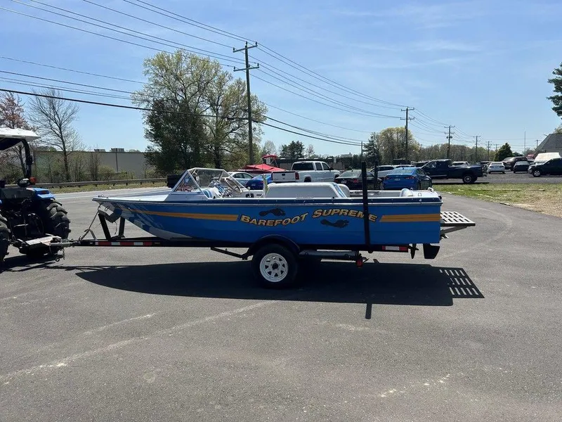 Slide: The Image of 1980 Ski Supreme boat on trailer, blue and yellow design, parked outdoors. - 5
