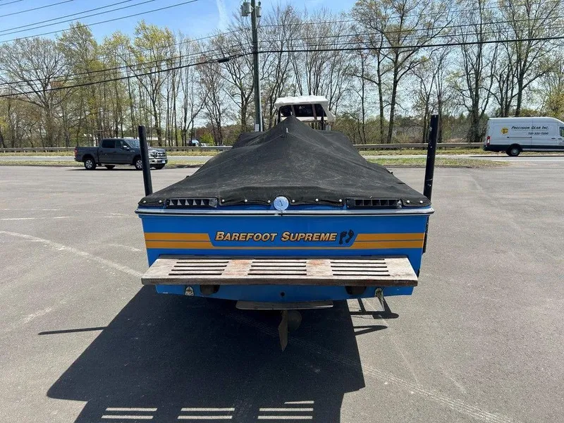 Slide: The Image of 1980 Ski Supreme boat with cover, parked in a lot, rear view. - 6