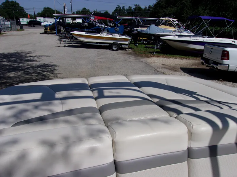 Slide: The Image of 2009 Chaparral 226 SSi boat interior with cushioned seating, parked among other boats. - 14