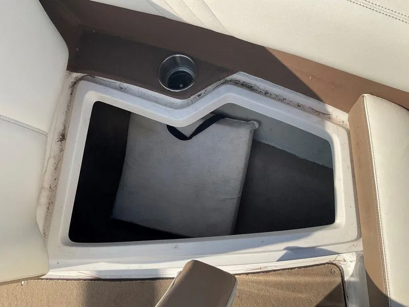 Slide: The Image of Storage compartment in a 2013 Cobalt 210 boat with cup holder and cushion. - 1