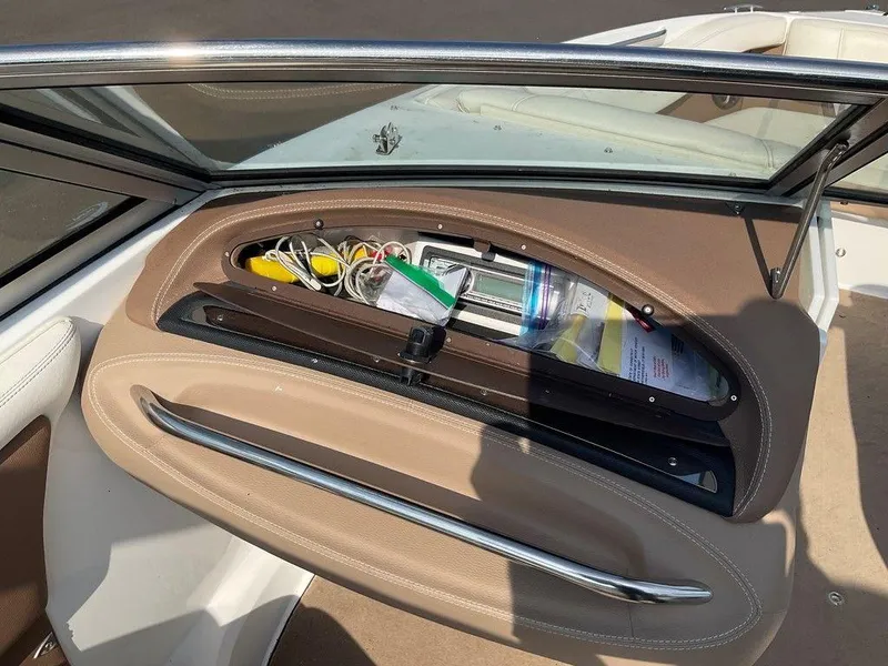 Slide: The Image of Storage compartment in a 2013 Cobalt 210 boat, containing various items and accessories. - 10