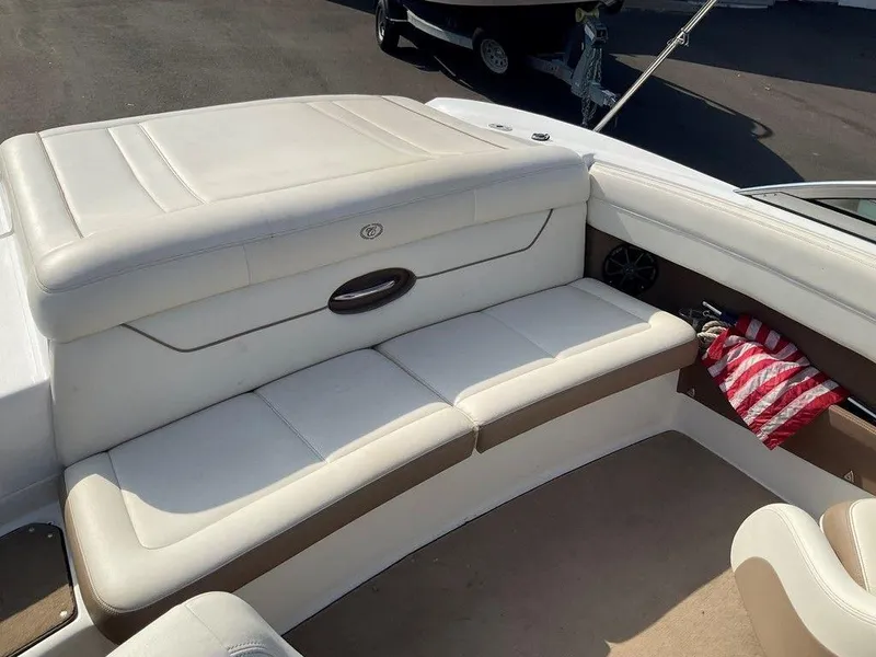 Slide: The Image of 2013 Cobalt 210 boat interior with white leather seating and storage compartment. - 11