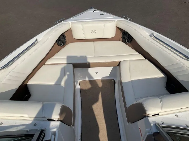 Slide: The Image of 2013 Cobalt 210 boat interior with white cushioned seating and shadow on deck. - 18