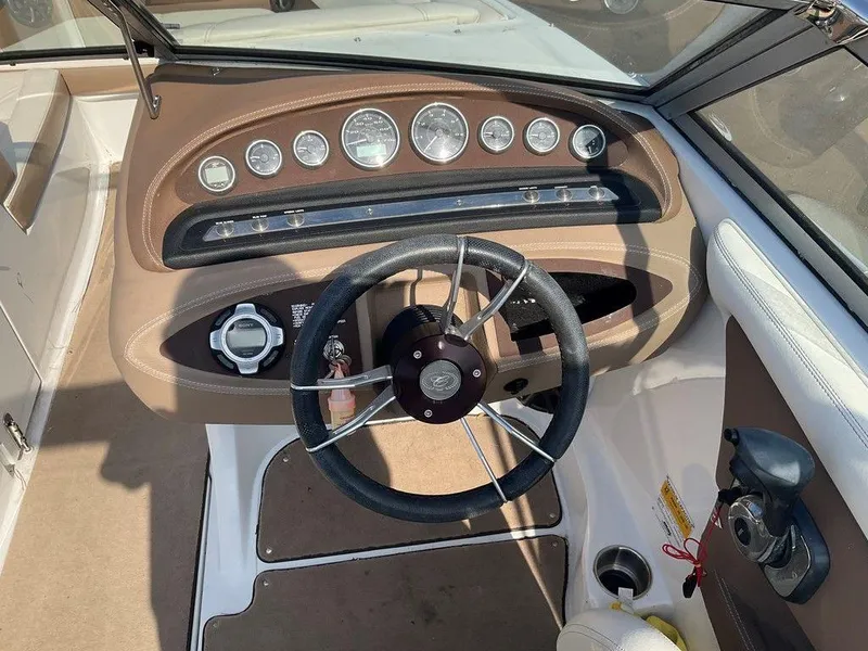 Slide: The Image of Steering wheel and dashboard of a 2013 Cobalt 210 boat, featuring multiple gauges. - 19