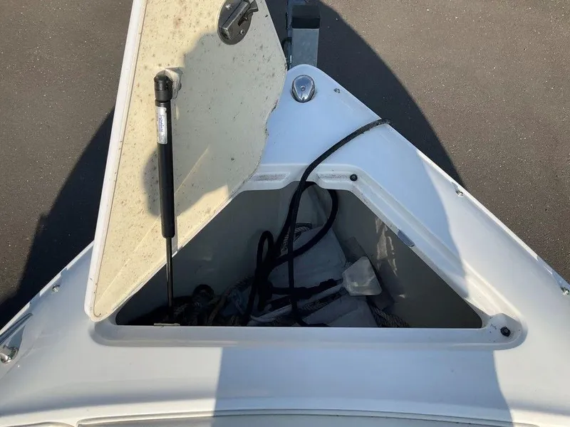Slide: The Image of Open storage compartment on a 2013 Cobalt 210 boat, showing ropes and equipment. - 7