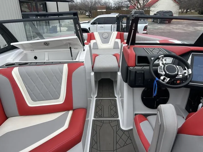 Slide: The Image of 2020 Tigé 23ZX boat interior with red and gray seating, modern dashboard, and steering wheel. - 3