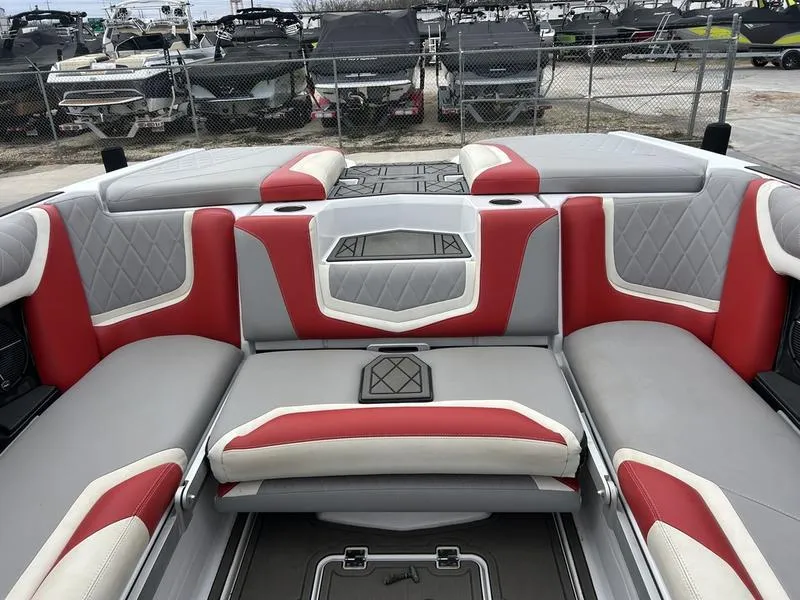 Slide: The Image of 2020 Tigé 23ZX boat interior with red and gray seating, diamond stitching, and storage compartments. - 4