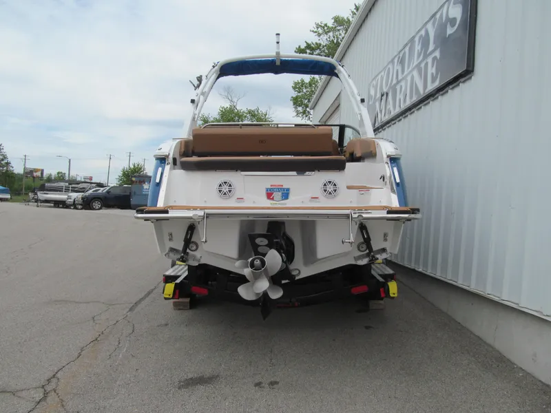 Slide: The Image of 2025 Cobalt R6 boat rear view at a marina, showcasing propeller and seating. - 5