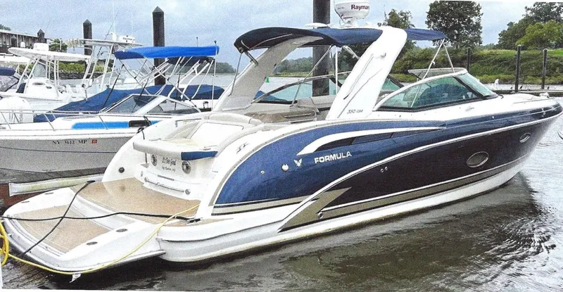 Slide: The Image of 2015 Formula 350 Crossover Bowrider boat docked in marina, featuring sleek design and blue accents. - 1