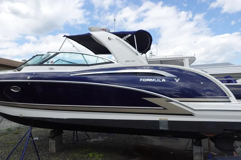 Slide: The Image of 2015 Formula 350 Crossover Bowrider boat on stands, under a partly cloudy sky. - 3