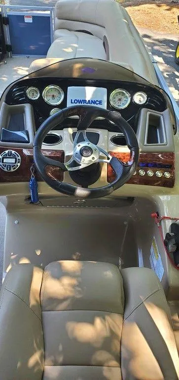 Slide: The Image of 2017 Regency 220 DL3 boat dashboard with steering wheel and Lowrance display. - 11