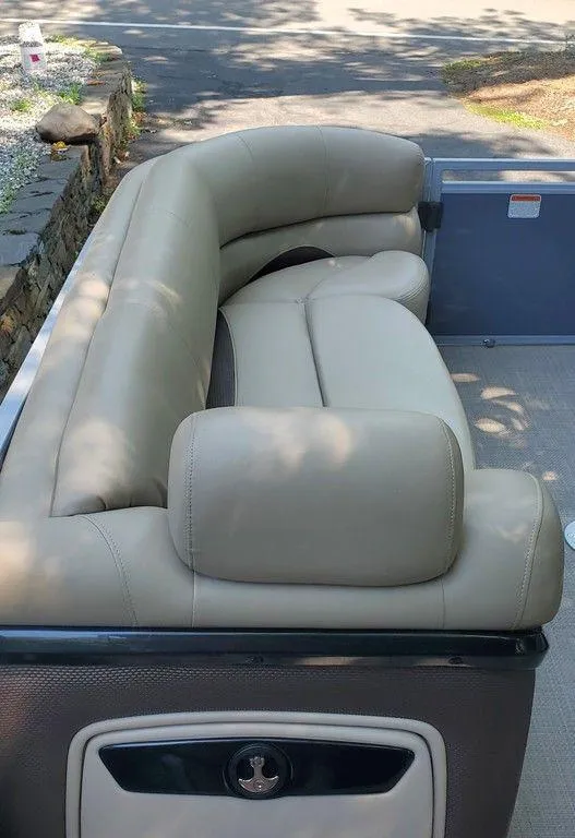 Slide: The Image of Luxurious seating on a 2017 Regency 220 DL3 pontoon boat, featuring beige leather upholstery. - 12