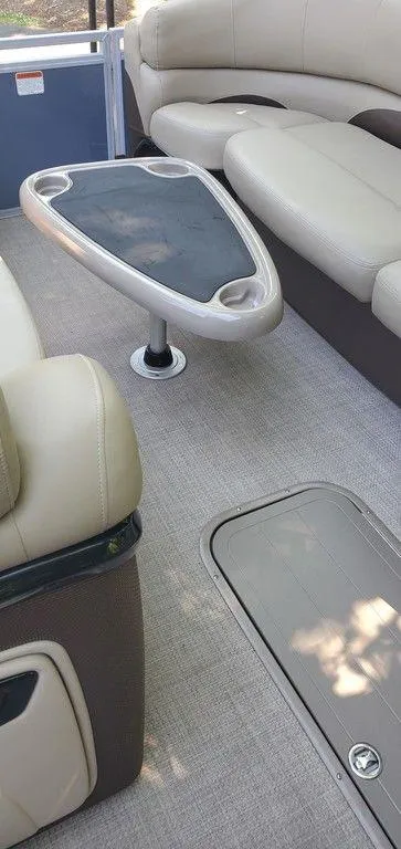 Slide: The Image of Interior of a 2017 Regency 220 DL3 boat with beige seating and a triangular table. - 15