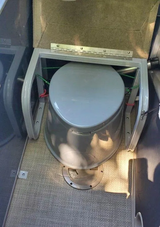 Slide: The Image of 2017 Regency 220 DL3 boat interior with portable toilet setup. - 16