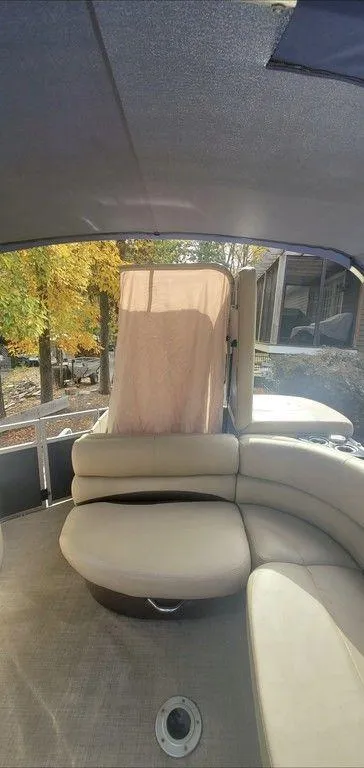 Slide: The Image of 2017 Regency 220 DL3 pontoon boat interior with beige seating and canopy. - 17