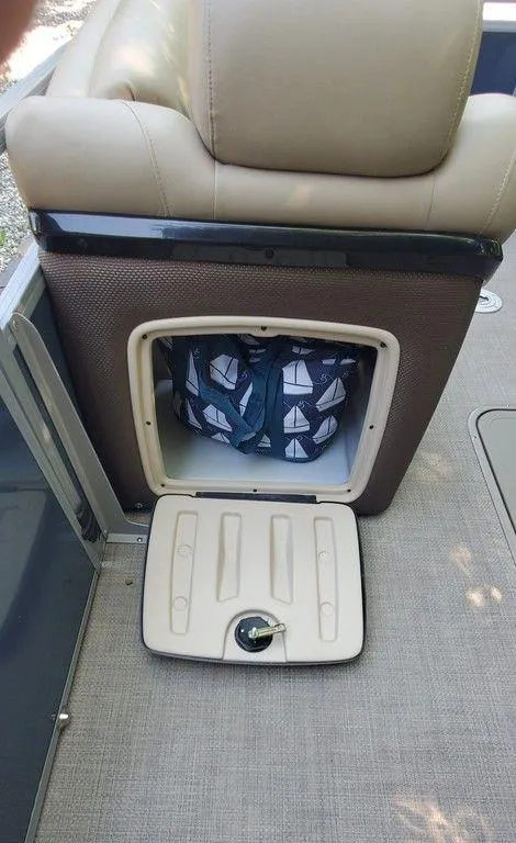 Slide: The Image of 2017 Regency 220 DL3 boat seat storage with nautical-themed bag inside. - 20