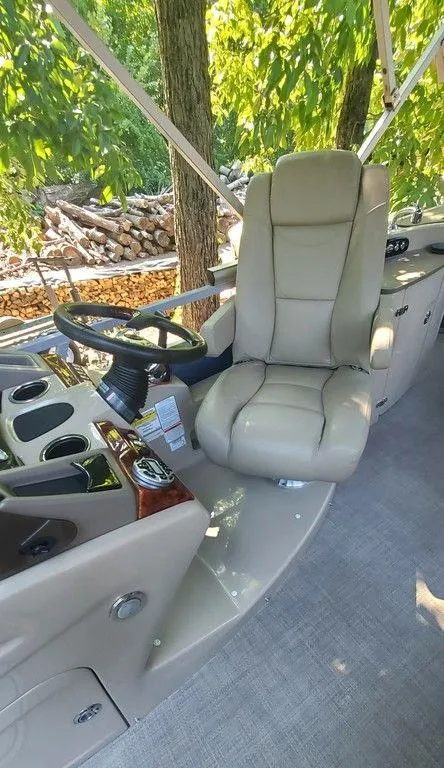 Slide: The Image of 2017 Regency 220 DL3 boat interior with beige captain's chair and steering wheel. - 22