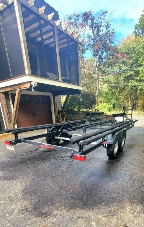 Slide: The Image of 2017 Regency 220 DL3 boat trailer parked on driveway near a modern house. - 30
