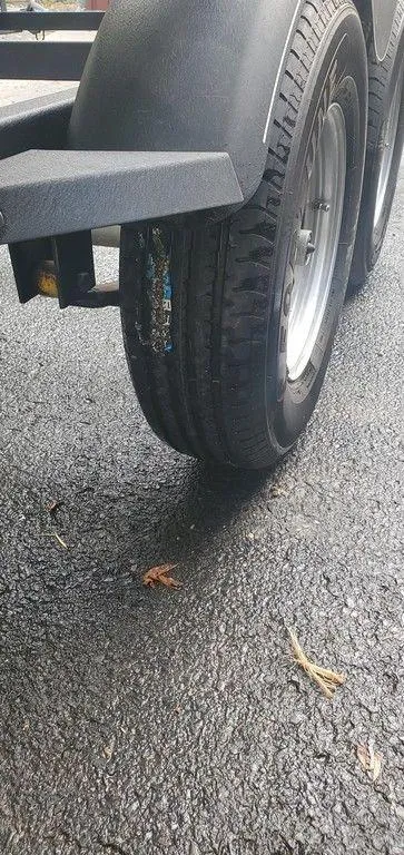 Slide: The Image of 2017 Regency 220 DL3 trailer tire on wet asphalt surface. - 31