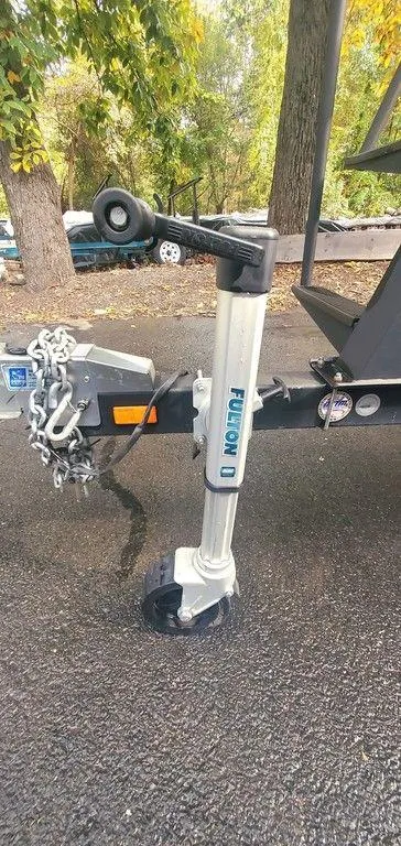 Slide: The Image of Trailer hitch and wheel of 2017 Regency 220 DL3 on asphalt, surrounded by trees. - 33