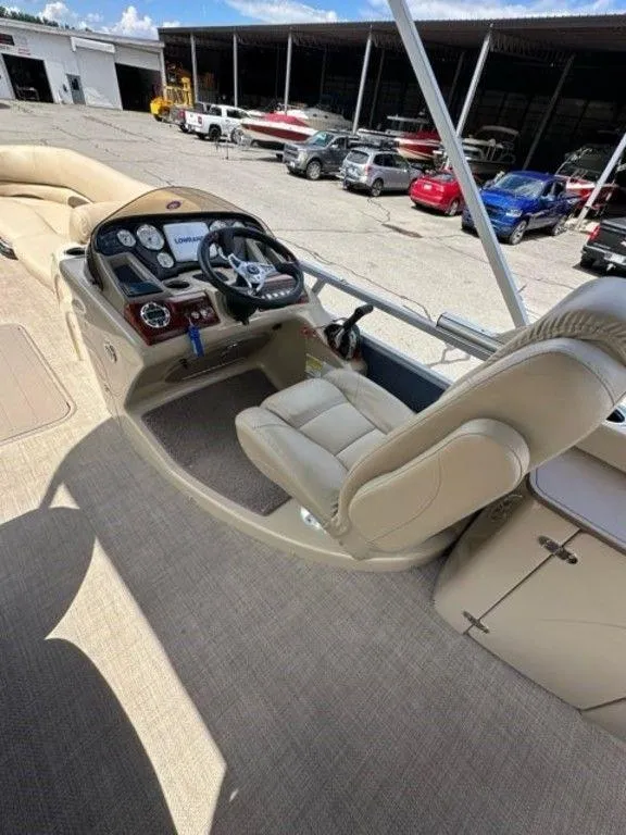 Slide: The Image of 2017 Regency 220 DL3 boat interior with steering console and beige seating. - 4