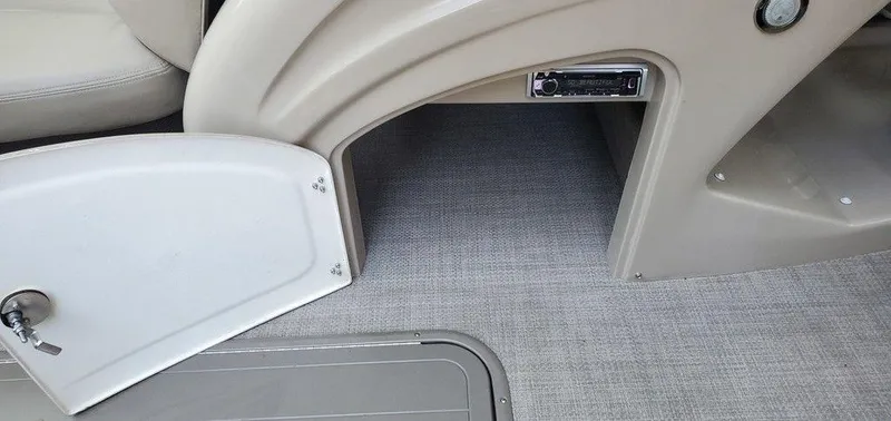 Slide: The Image of 2017 Regency 220 DL3 boat interior with open storage compartment and stereo system. - 47