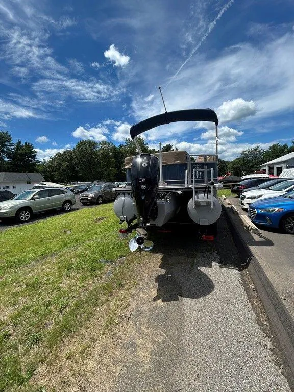 Slide: The Image of 2017 Regency 220 DL3 pontoon boat parked outdoors under a blue sky. - 48