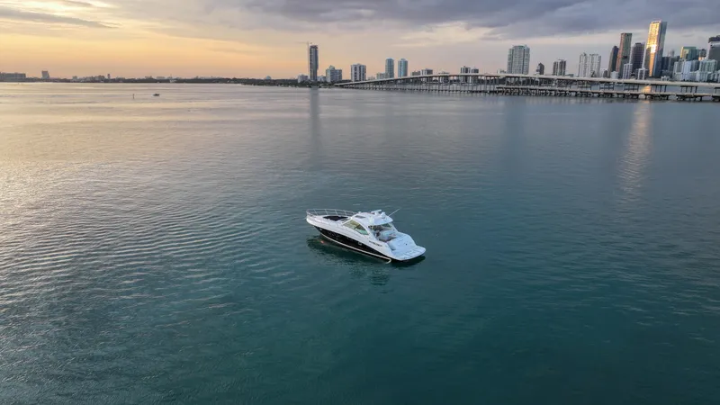 Slide: The Image of 2008 Sea Ray 48 Sundancer yacht on calm water near city skyline at sunset. - 15