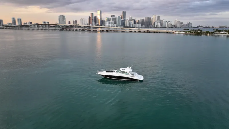 Slide: The Image of 2008 Sea Ray 48 Sundancer yacht on calm water with city skyline in the background. - 18