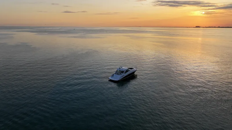 Slide: The Image of 2008 Sea Ray 48 Sundancer yacht on calm water at sunset. - 21