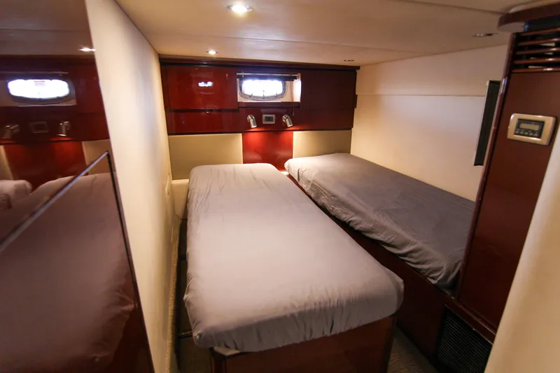 Slide: The Image of 2008 Sea Ray 48 Sundancer cabin with twin beds and wooden interior. - 23