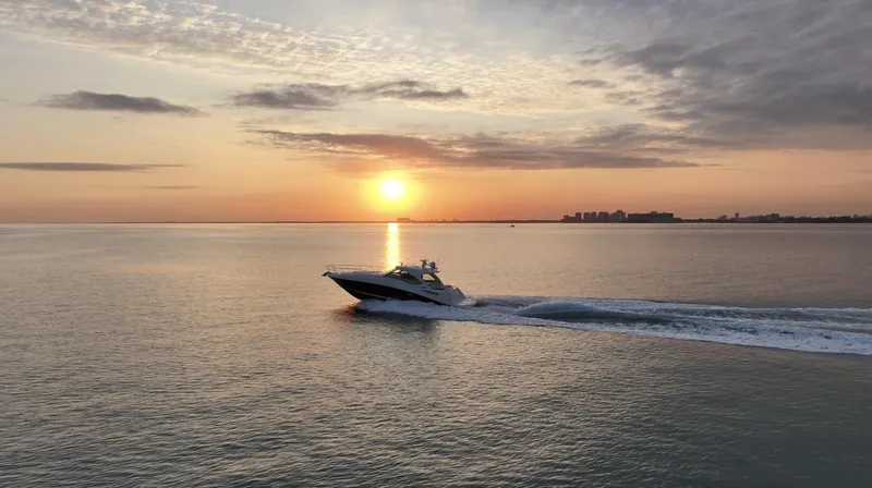 Slide: The Image of 2008 Sea Ray 48 Sundancer cruising at sunset on calm waters. - 42