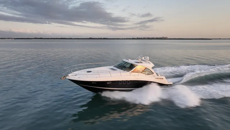 Slide: The Image of 2008 Sea Ray 48 Sundancer cruising on calm waters at sunset. - 44