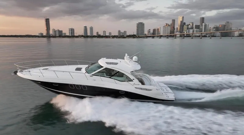 Slide: The Image of 2008 Sea Ray 48 Sundancer yacht cruising near city skyline at sunset. - 45