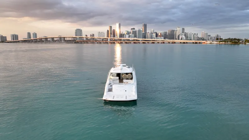 Slide: The Image of 2008 Sea Ray 48 Sundancer yacht cruising near city skyline at sunset. - 8