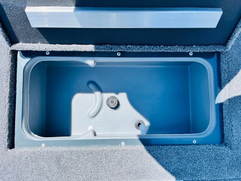 Slide: The Image of 2025 Ranger RT188C boat livewell, empty and open, with gray interior and carpeted edges. - 22
