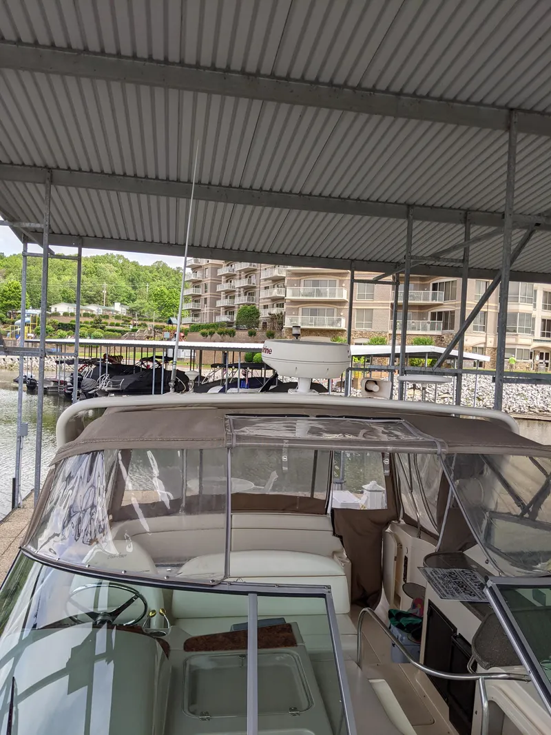 Slide: The Image of 2004 Rinker Fiesta Vee 410 docked under covered marina with scenic background. - 10