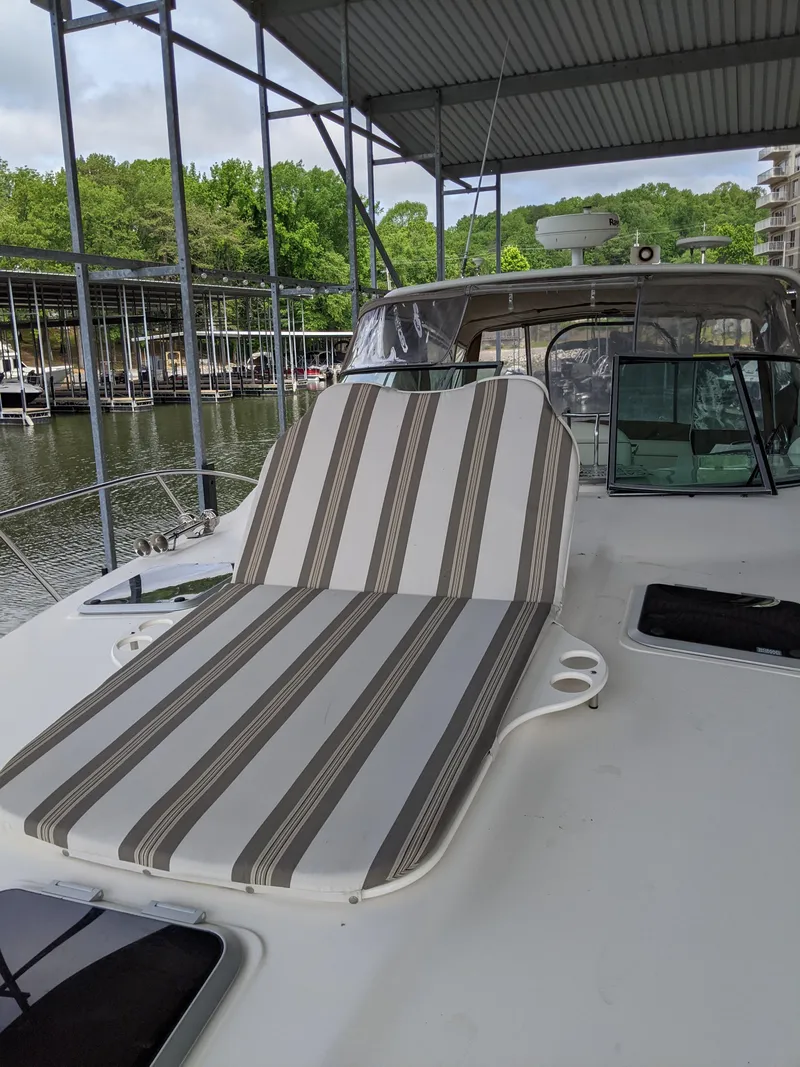 Slide: The Image of 2004 Rinker Fiesta Vee 410 yacht with striped deck chair under covered dock. - 12
