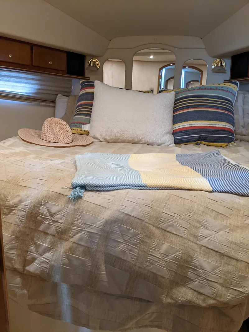 Slide: The Image of Cozy cabin bedroom in 2004 Rinker Fiesta Vee 410 yacht with striped pillows and a straw hat. - 18