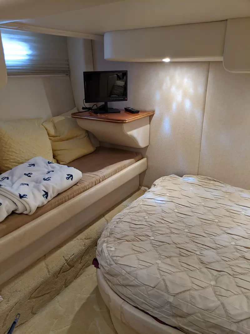 Slide: The Image of 2004 Rinker Fiesta Vee 410 cabin interior with bed, seating, and TV. - 20