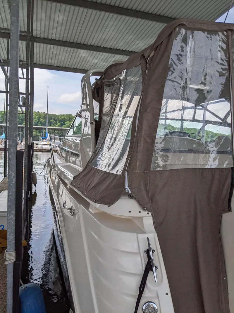 Slide: The Image of 2004 Rinker Fiesta Vee 410 boat docked under a covered marina. - 3