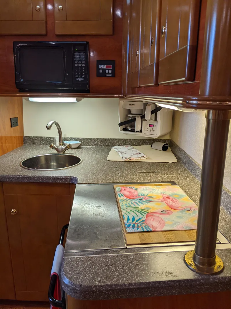 Slide: The Image of 2004 Rinker Fiesta Vee 410 kitchen with sink, microwave, and countertop. - 31