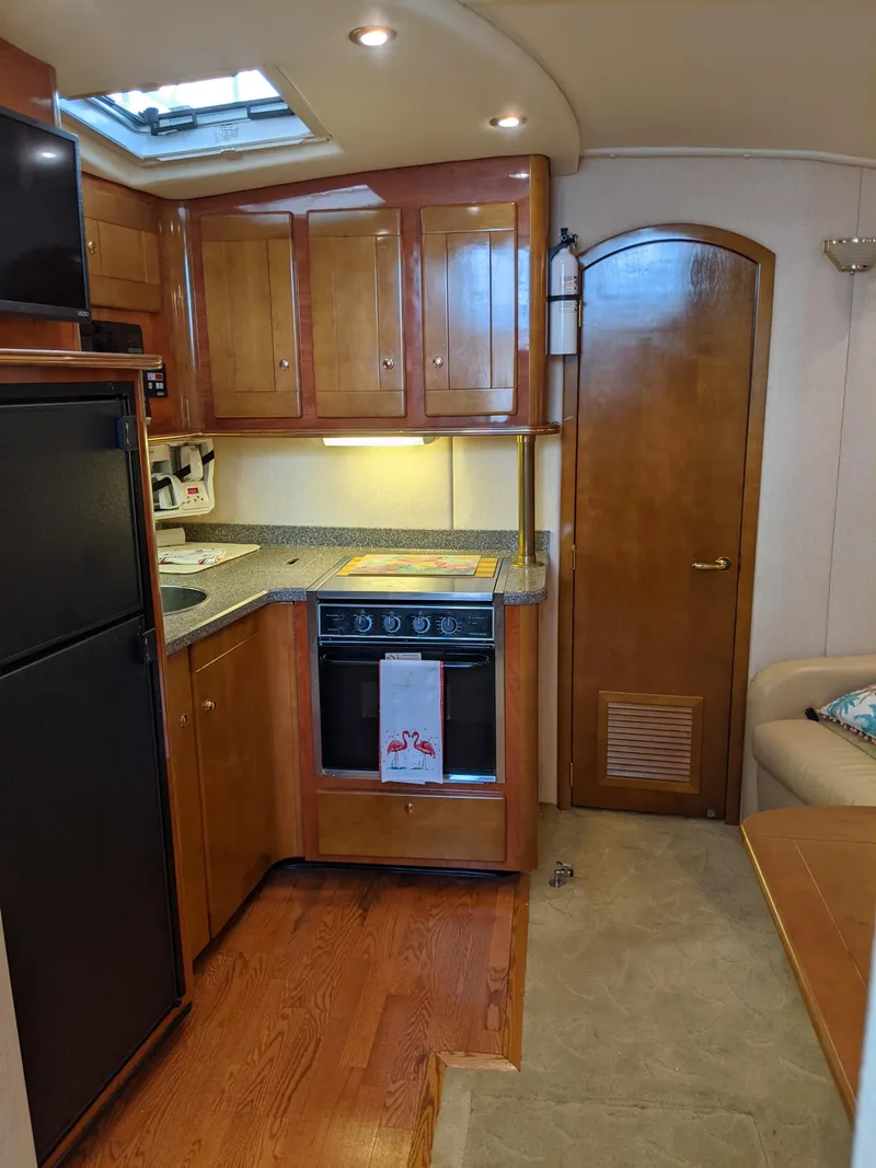 Slide: The Image of 2004 Rinker Fiesta Vee 410 yacht kitchen with wood cabinets and modern appliances. - 32