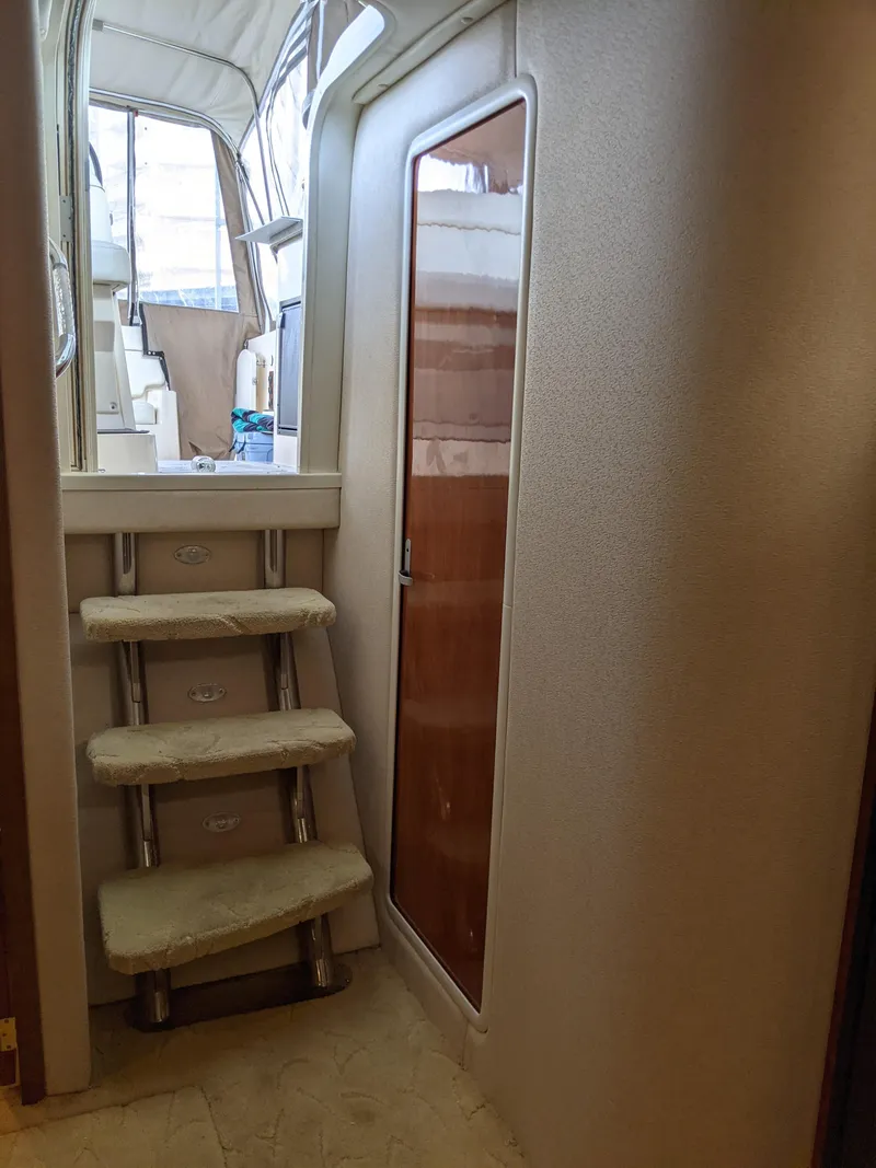 Slide: The Image of 2004 Rinker Fiesta Vee 410 interior with stairs and wooden door. - 33