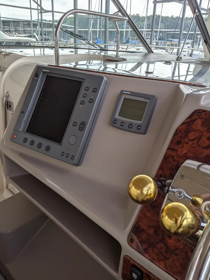 Slide: The Image of 2004 Rinker Fiesta Vee 410 helm with navigation controls and display. - 40