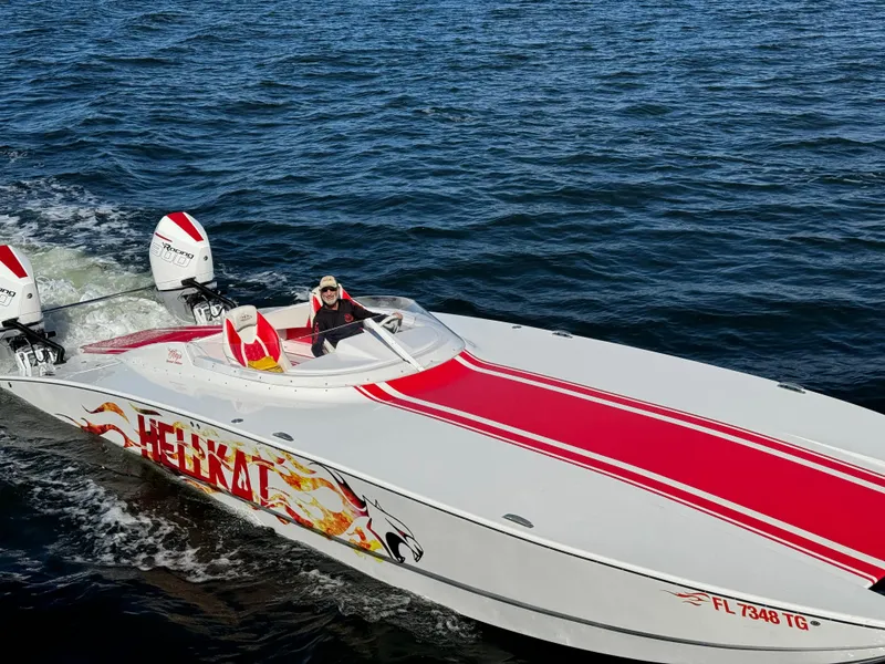Slide: The Image of 2022 HellCat 32 Wide Body speedboat with red accents cruising on open water. - 1