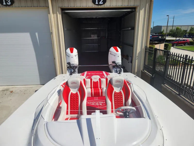 Slide: The Image of 2022 HellCat 32 Wide Body boat with red and white interior, dual engines, docked in a garage. - 5