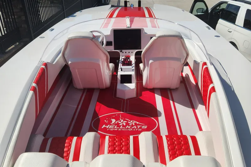 Slide: The Image of 2022 HellCat 32 Wide Body boat interior with red and white seating and dashboard. - 7