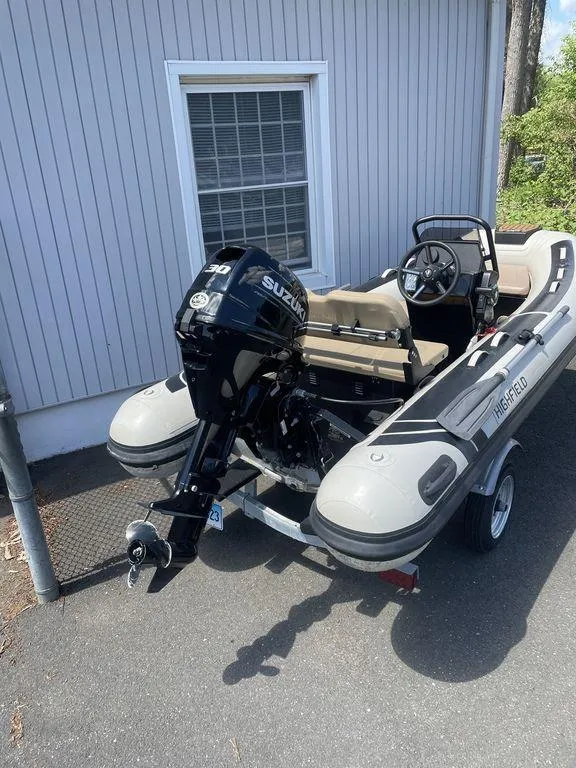 Slide: The Image of 2023 Highfield Classic 380 GT Limited inflatable boat with Suzuki outboard motor, parked on trailer. - 11